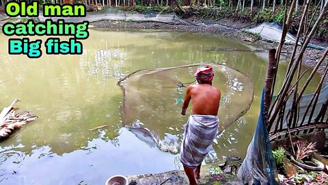 Traditional village Old man catching fish from pond