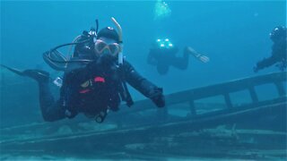 Imaginative scuba driver mimes a comical explanation of a historic shipwreck