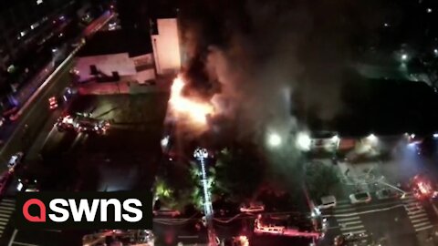 Drone footage shows a strip of shops in New York's Harlem district engulfed in flames
