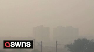 Thick fog plunges fields and tower blocks in India into darkness