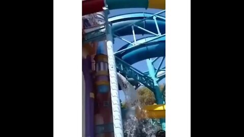 A massive water slide has snapped in half and collapsed to the ground.