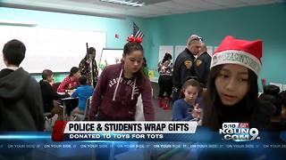 Police and students wrap gifts for toys for tots