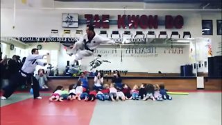 Tae Kwon Do master leaps over 16 children and breaks board