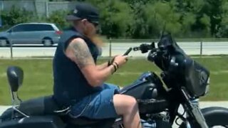 Biker uses cell phone with both hands while on freeway
