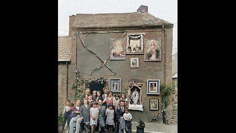 A large Irish family in the background of their home. 1950-е