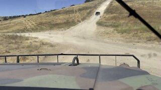 in the passenger seat of a military vehicle.