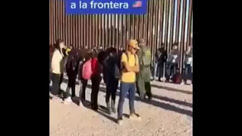 American border patrol guards organizing migrants at the US-Mexico border