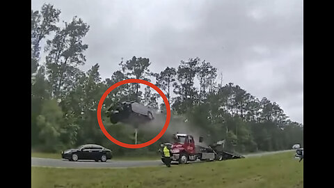 Distracted driver hits tow truck and goes flying!