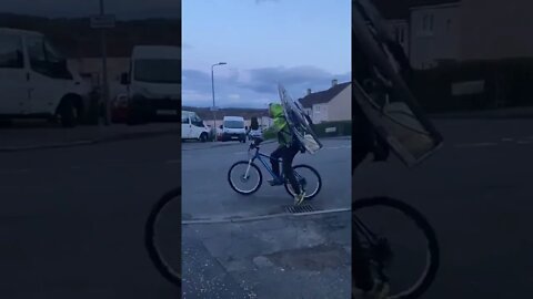 British Man With Giant Fan Propeller On Back Boosts Peddle Bike Down Road