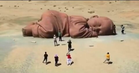 Giant sleeping baby 👶🏻 This sculpture of a sleeping baby is located in the desert of Guazhou,