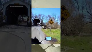 Riding a motorcycle through Bucher's Mill covered Bridge near Denver PA.