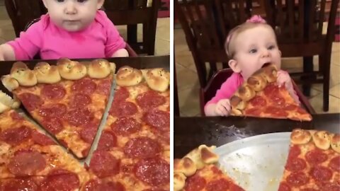 Baby loves to eat big slice of pizza