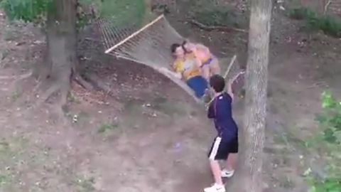 A Young Boy Jumps On A Swinging Hammock But Falls Out The Other Side