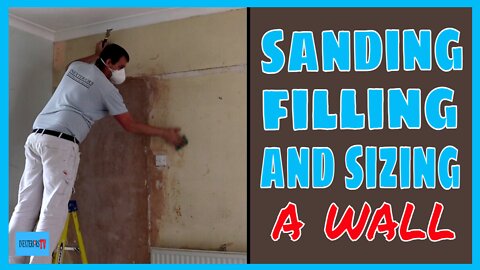 Sanding, filling, and sizing a wall.