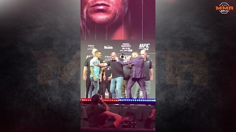Conor McGregor throws a kick at Dustin Poirier during the UFC 264 press conference face-off