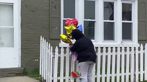 Childhood friend places balloons outside shooting victim's home