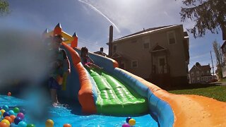 Kids Playing outside on Bouncy House Slide Pool