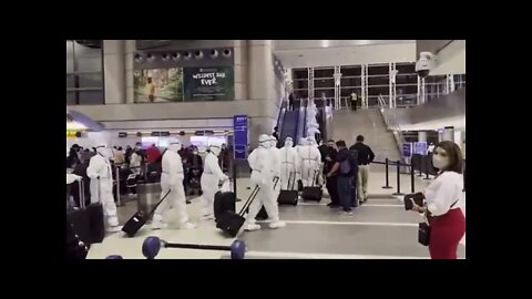 Chinese Guohang Airlines staff wear protective gear while walking through LAX airport in America