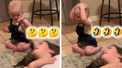 Shocked baby realises she has no hair after touching mom's hair.