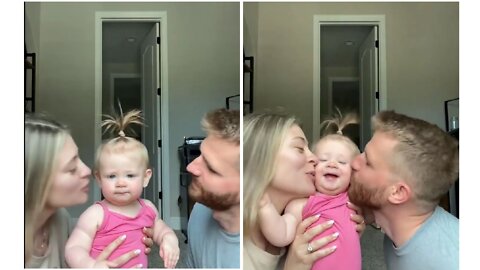 Parents kiss their little baby girl