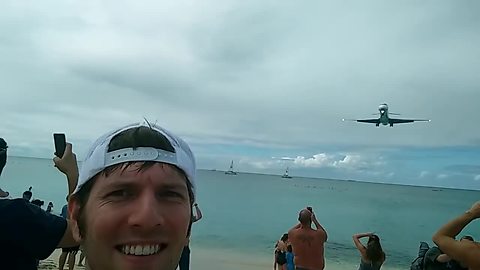 Tourists stand beneath airplane landing in St. Maarten