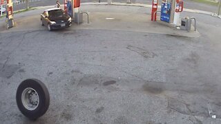 Runaway truck tire meets car parked at gas pump