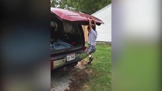 A Tot Boy Holds On To The Back Of A Car As The Door Lifts Up