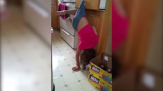 "Little Girl Hangs By Her Shorts On Drawer Handle"