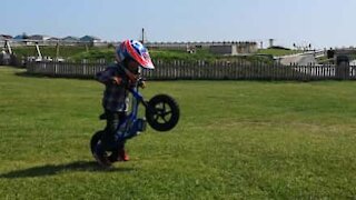 Un petit garçon joue les durs sur sa moto