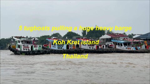 5 tugboats pulling a huge heavy barge at Koh Kret island Thailand
