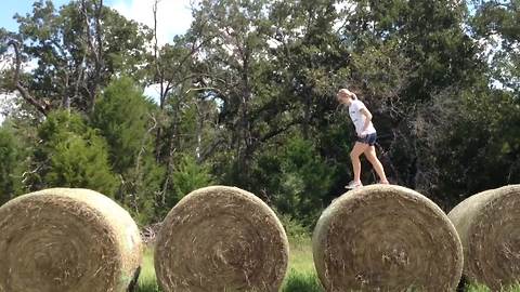 A Teen Girl Runs Across Large Bales Of Hay But Fail To Finish Her Race