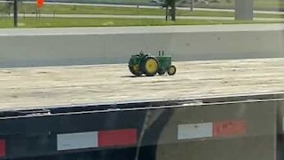 Jeep tows toy tractor on huge trailer