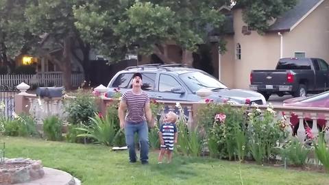 A Young Man And A Tot Boy Play Watermelon Throw Game