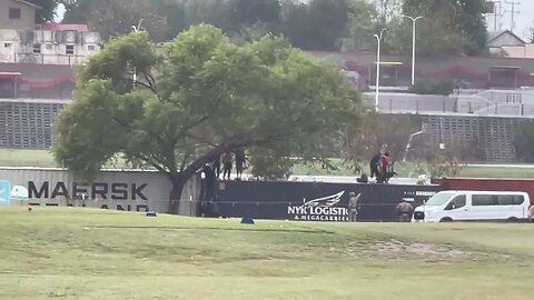 A group of migrants scaled the Conex boxes lined up along the Rio Grande in