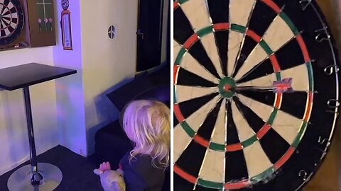 Little girl hits perfect bullseye at first try throwing darts