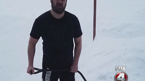 Man shovels snow in shorts