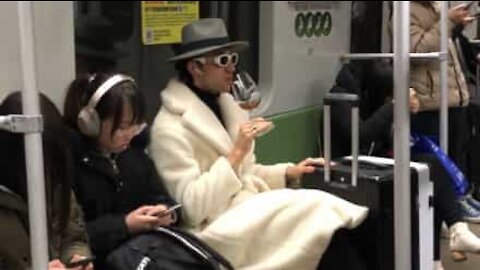 Homem estiloso bebe chá em copo de vinho no metro na China