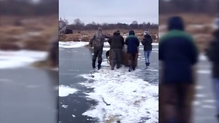 Extreme cold forces villagers to move hay bales across frozen river
