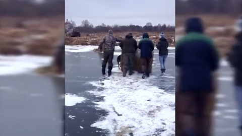 Extreme cold forces villagers to move hay bales across frozen river