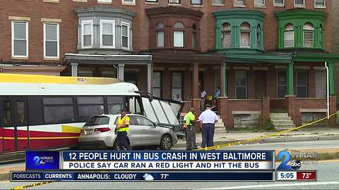 12 injured after car runs red light, hits MTA bus