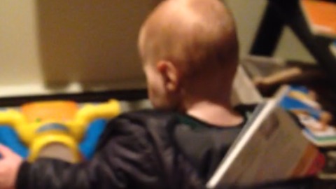 A Toddler Gets His Book Stuck In His Hoodie