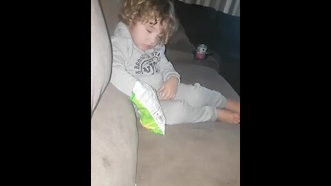 Kid struggles to stay awake to eat chips