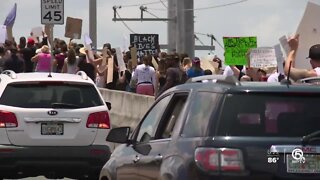 Protesters march across Roosevelt Bridge in Stuart