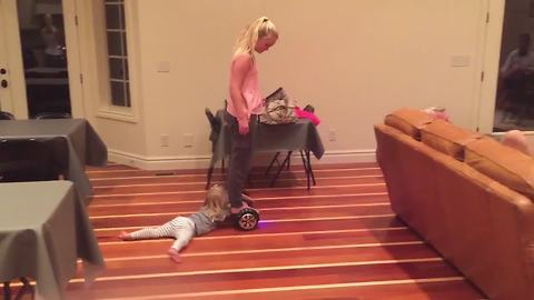 A Young Girl Rides A Hoverboard And Drags Her Tot Sister Around A Room
