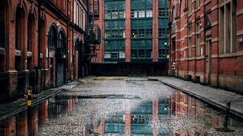 Rain on cobblestoned Winser Steet next to Victorian red bricked industrial buildings