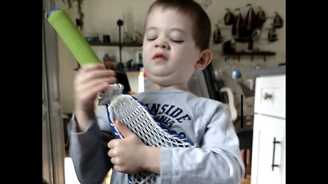 4 year old has epic air guitar session with toy lacrosse stick