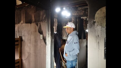 Malcom Wilson showing off his mother's flat that was burnt down