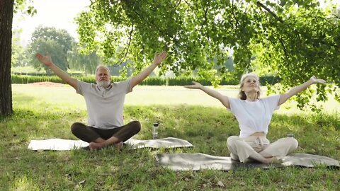 couple doing calming yoga in the park