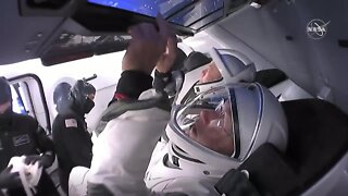 Astronauts get buckled into spacecraft
