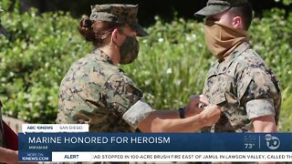 Marine disarms sailor pointing rifle at women and children
